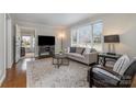Cozy living room featuring neutral tones, hardwood floors, a large window, and comfortable seating at 3231 Eastwood Dr, Charlotte, NC 28205