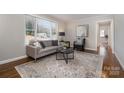 Bright living room with hardwood floors, large window, stylish furnishings, and a view of the front yard at 3231 Eastwood Dr, Charlotte, NC 28205