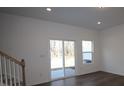 Open-concept living room with wood floors, sliding glass doors to the backyard and staircase at 3427 Secrest Lndg, Monroe, NC 28110
