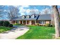 Inviting brick home featuring a covered front porch and lush green lawn at 4025 4Th Street Nw Ln, Hickory, NC 28601