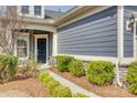 Inviting entrance with a stylish black door, manicured bushes, and a charming walkway at 4521 Middlebury Ln, Fort Mill, SC 29715
