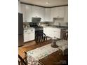 Well-lit kitchen with white cabinets, stainless steel appliances, granite countertops, and eat-in area at 4805 Nesbit Rd, Monroe, NC 28112