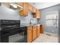 Well-lit kitchen with wooden cabinets, granite countertops, and modern black appliances at 624 Harris Nw St, Concord, NC 28025
