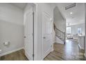 Bright entryway showcasing white doors, wood floors and staircase leading to upper level at 7006 Everly Commons Ln, Tega Cay, SC 29708