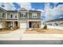 Charming two-story townhouse showcasing stone accents, a one-car garage and a welcoming front porch at 8157 Merryvale Ln, Charlotte, NC 28214