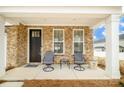 Charming front porch featuring a seating area, complemented by stone accents and a welcoming entrance at 8157 Merryvale Ln, Charlotte, NC 28214