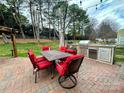 Outdoor kitchen and dining space with a built-in grill, perfect for outdoor cooking and entertaining at 8932 Raven Park Dr, Charlotte, NC 28216