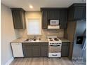 Modern kitchen featuring stainless steel appliances, gray cabinets, and granite countertops at 920 Oakridge Farm Hwy, Mooresville, NC 28115