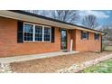 A closer look at the brick facade, decorative shutters, and a welcoming front door, adding to its curb appeal at 104 Pop Davis Rd, Taylorsville, NC 28681