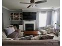 Cozy living room with a fireplace, built-in shelving, and comfortable seating arrangement at 12123 Monteith Grove Dr, Huntersville, NC 28078