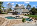 This private backyard features a pool, hot tub, patio, and lush landscaping at 125 Arrow Point Ln, Davidson, NC 28036