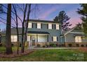 Charming two-story home with stone accents, a covered front porch, and lush landscaping at 125 Arrow Point Ln, Davidson, NC 28036