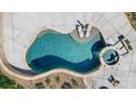Overhead view of an inground pool with spa and tanning ledge, framed by travertine and concrete decking at 125 Arrow Point Ln, Davidson, NC 28036