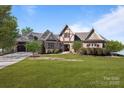 Beautiful stone and Tudor-style home with well-manicured lawn and lush landscaping at 134 Larkhaven Ln, Mooresville, NC 28117