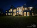 Expansive waterfront estate featuring multiple balconies and beautiful architecture at twilight at 134 Larkhaven Ln, Mooresville, NC 28117