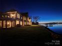 Beautiful waterfront home and pier at dusk provide a scenic view of the sunset at 134 Larkhaven Ln, Mooresville, NC 28117