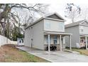 Two-story home with a front porch, long driveway, and a small storage building in the backyard at 1766 15Th Street Ne Pl, Hickory, NC 28601