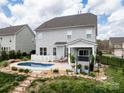 Backyard featuring an in-ground pool, a covered patio with seating, and landscaped garden area at 2033 Folkstone Ln, Indian Land, SC 29720