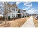 Street view of well maintained townhomes with landscaped front yards and sidewalks under a sunny sky at 2130 Blewett Dr, Charlotte, NC 28269