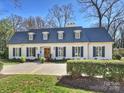 Charming two-story home with a gray roof, complemented by black shutters and meticulous landscaping at 2423 Lemon Tree Ln, Charlotte, NC 28211