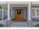 Inviting front entrance with custom wood doors, stone accents, and manicured landscaping at 2615 Farm House Ln, Monroe, NC 28110