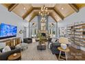 Bright living room with vaulted ceilings, wood beams, large windows, a stone fireplace, and hardwood floors at 2615 Farm House Ln, Monroe, NC 28110