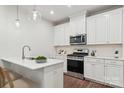 Bright kitchen features stainless appliances, white cabinets, pendant lights, and a breakfast bar with seating at 3051 Finchborough Ct # 219, Charlotte, NC 28269