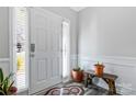 Bright entryway featuring a white front door with sidelight, bench and decorative plants at 571 Rough Hewn Ln, Rock Hill, SC 29730
