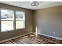Bedroom with ample natural light streaming through two windows, highlighting the room's hardwood floors and neutral color scheme at 6756 Denver Heights Cir, Denver, NC 28037
