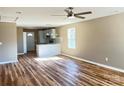 Bright open-concept living space with hardwood floors, seamlessly flowing into a modern kitchen with marble countertops and pendant lighting at 6756 Denver Heights Cir, Denver, NC 28037