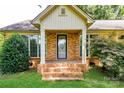Inviting front porch with classic brick steps, white columns, and decorative door with sidelight windows at 7770 Sherrills Ford Rd, Sherrills Ford, NC 28673