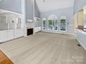 Bright living room with high ceilings, large windows, fireplace, and built in shelving at 1421 Wilburn Park Nw Ln, Charlotte, NC 28269