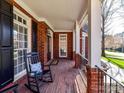 Charming front porch with brick flooring, rocking chairs and white columns at 18322 Indian Oaks Ln, Davidson, NC 28036