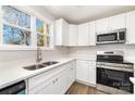 Bright kitchen features white cabinets, stainless steel appliances, an island, and wood-look floors at 2206 Hillcrest Ave, Albemarle, NC 28001