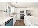 Bright kitchen features white cabinets, stainless steel appliances, an island, and wood-look floors at 2206 Hillcrest Ave, Albemarle, NC 28001