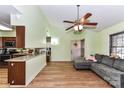 Open-concept living room with a view of the kitchen, wood floors, and a cozy gray sofa at 2652 Gabriel Ct, Fort Mill, SC 29715