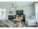 Cozy living room with a fireplace, ceiling fan, hardwood flooring, and a comfortable seating arrangement at 4586 Antelope Ln, Charlotte, NC 28269