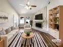 Bright living room featuring a stone fireplace, ceiling fan, and coordinated furniture and decor in neutral tones at 4808 Cedar Ct, Gastonia, NC 28056