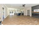 An open-concept living room featuring a fireplace, ceiling fan, and seamless access to the kitchen at 603 N Elm St, Cherryville, NC 28021