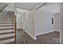 Hallway that leads to a living room area with wood-look floors and staircase at 606 N Elm St, Marshville, NC 28103