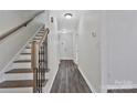 Bright hallway with wood-look floors and a staircase with wood and black metal railings at 606 N Elm St, Marshville, NC 28103