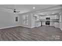 Open-concept living room and kitchen area with gray wood-look floors and bright white walls at 606 N Elm St, Marshville, NC 28103
