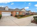 Brick home showcasing a two-car garage, well-maintained lawn, and inviting curb appeal at 8439 Sonata Ct, Denver, NC 28037