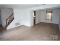 Spacious living room with wood-look floors and staircase at 8915 Touchstone Ln, Charlotte, NC 28227