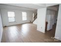 Open-concept living room with plenty of natural light and wood-look floors at 8915 Touchstone Ln, Charlotte, NC 28227