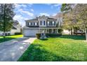 Beautiful two-story home with a lush green lawn, complemented by well-maintained landscaping and mature trees at 110 Hazelton Loop, Mooresville, NC 28117