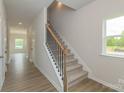 Inviting hallway with wood floors, staircase with decorative metal, and a window that brings in light at 1101 Red River Dr, Salisbury, NC 28144