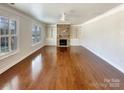 Living room features hardwood floors, built-in shelves, and a stacked stone fireplace at 11123 River Oaks Nw Dr, Concord, NC 28027