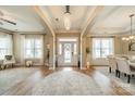 Inviting foyer featuring wood floors, elegant lighting, and an open floor plan leading to the dining area at 1122 Saratoga Blvd, Indian Trail, NC 28079