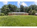 Well-maintained, single-story home with brick facade and lush greenery, showcasing serene, suburban living at 1210 Brookwood Dr, Shelby, NC 28150